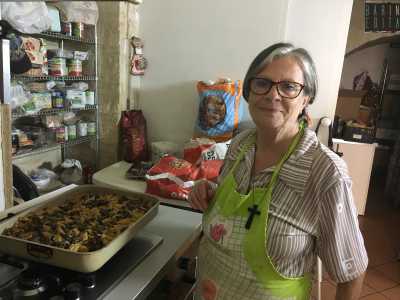 La donna mostra con orgoglio una splendida teglia di pasta al forno con i funghi, pronta per essere messa a cuocere: sar� servita come primo per il pranzo